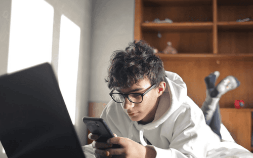 un ado lisant un article ayant comme titre : Orientation scolaire : aider votre ado à réduire son temps d’écran pendant les révisions du bac